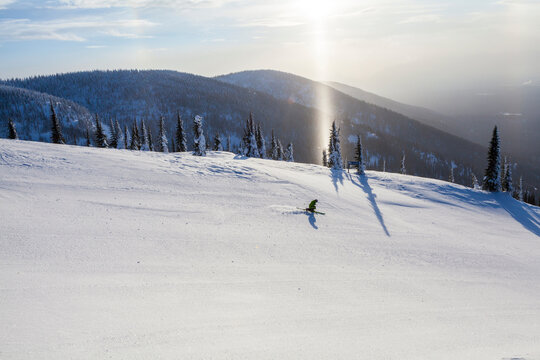 Distant View Of A Lone Skier On Snowy Landscape In Whitefish, Montana, Usa