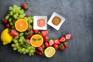 Various fruits and spices on dark gray background