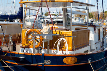 A very expensive wooden yacht in an Athens harbor. Wooden steering wheel.