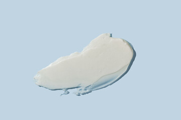 White cosmetic cream texture on blue background. Skin care product smear. Lotion, hair mask or...