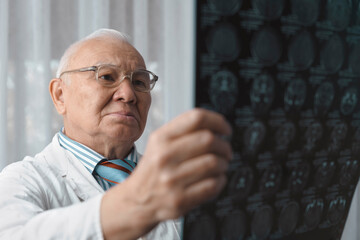 Senior doctor examining x-ray Image at hospital