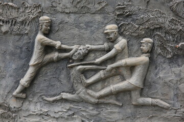 Memorial shrine festooned with bas-reliefs of Khmer Rouge atrocities at Wat Somrong Knong. Cambodia.