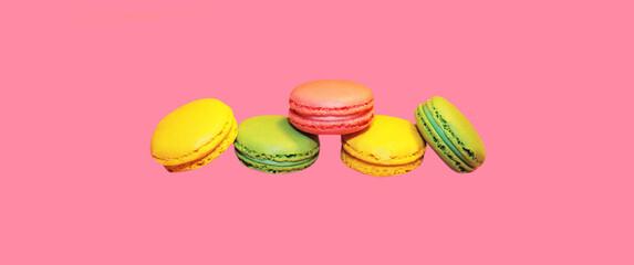 Multicolored sweet macaroons on pink background