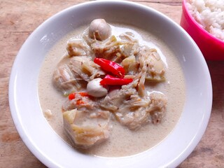 Sayur nangka is Indonesia vegetable soup made from young jackfruit, coconut milk. served in a bowl on a wooden table