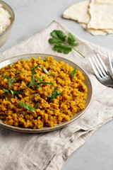 Homemade Red Lentil Dahl with Rice and Cilantro on a gray background, side view.