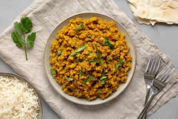 Homemade Red Lentil Dahl with Rice and Cilantro on a gray background, top view. Flat lay, overhead, from above.