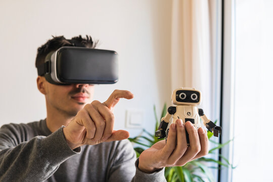 Businessman Wearing VR Glasses Analyzing Robot Model In Office