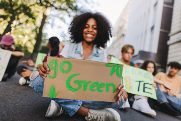 Happy teenage girl holding a poster at a climate protest