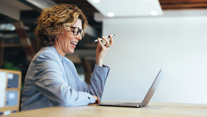 Business woman smiles as she talks to an associate on a mobile phone