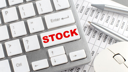 STOCK text on a keyboard wirh chart and pencil
