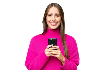 Young beautiful caucasian woman over isolated background looking at the camera and smiling while using the mobile