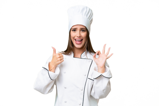 Young chef caucasian woman over isolated background showing ok sign and thumb up gesture