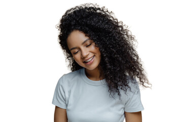 Photo of pleased satisfied woman smiles with pleasure, closes eyes and shows snow white teeth, has curly hairstyle, wears casual t shirt, poses against beige background. Happiness, joy concept - obrazy, fototapety, plakaty