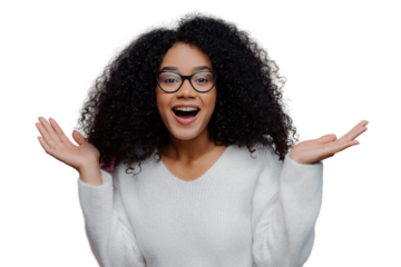 Portrait of joyful curly lady raises arms and spreads palms, wears optical glasses and white sweater, gets pleasant unexpected surprise from close person, isolated on violet studio wall. Happiness