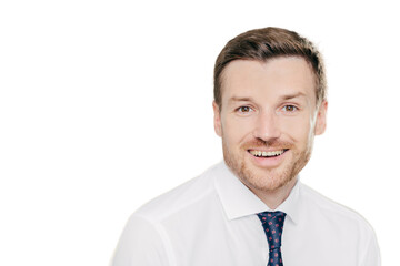 Studio shot of handsome unshaven male entrepreneur with cheerful expression, rejoices raising sales, dressed in formal clothes, isolated over white background with copy space aside for your text