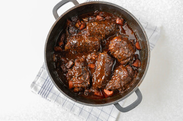 Beef roulades with gravy and roasted vegetables in a roasting pan before sieving. Cooking, making, preparation. Part of a series