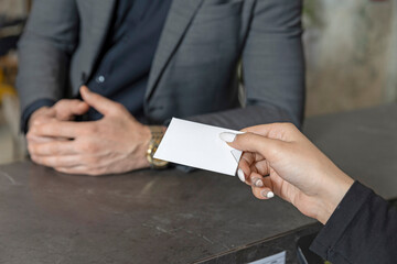 Receptionist giving card key to guest close up hands