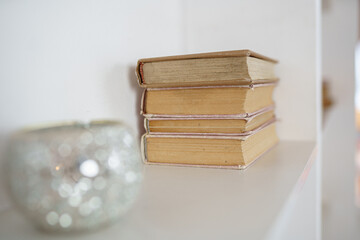 old vintage book on light shelf with candle horizontal placement