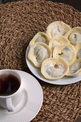 photo lots of chocolate dumplings lying on a white plate and a white coffee cup with coffee