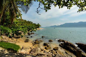 Small beach surrounded by tropical forest. Ilhabela's blue sea seen from the top of the hiking trail. São Paulo
