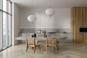 Light kitchen interior with dining table and armchairs, cooking zone