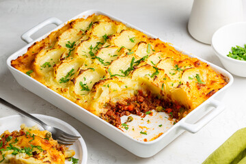 English Shepherd's pie, or cottage pie, or French version hachis Parmentier. Cooked minced beef meat with vegetables topped with mashed potato and baked. - obrazy, fototapety, plakaty