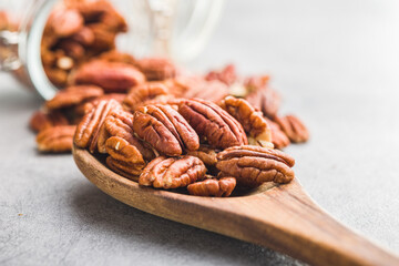 Peeled pecan nuts in wooden spoon.