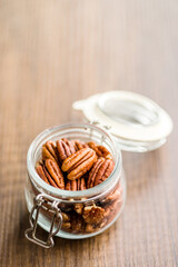 Peeled pecan nuts in jar on kitchen table.
