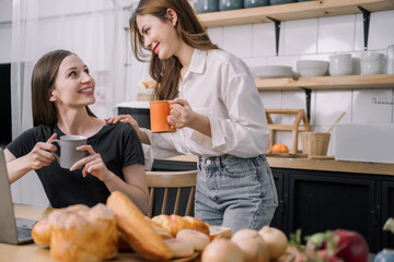 Young women enjoy talking while drinking milk in the kitchen in the morning concept.