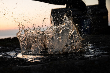 Photographie d'une personne sautant dans une flaque d'eau durant la golden hour en Bretagne.
