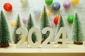 Happy New Year 2024 festive background with christmas tree on white brick wall background