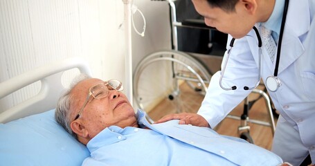 Obraz premium Asian medical doctor with stethoscope caring senior old patient on bed in hospital