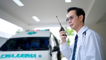 Paramedic using a radio to report an emergency at hospital