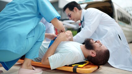 Emergency medical team provides first aid to the injured, lying on a stretcher