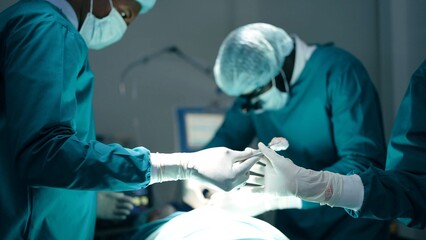 African American professional team of doctors and surgeons processing surgical operation in...