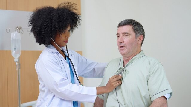African American female medical doctor talked and recheck the symptoms of the patient after treatment with elderly man patient in the hospital