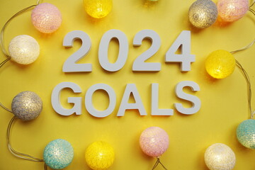 2024 Goals New Year resolution with LED cotton balls on yellow background