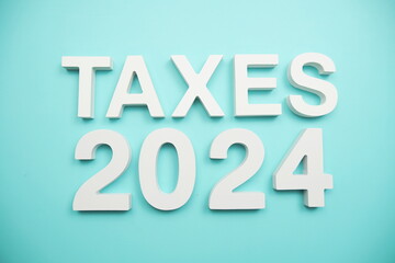 Taxes 2024 alphabet letters on blue background
