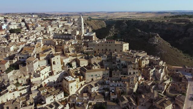 Aerial footage of Sassi di Matera in Basilicata, South Italy.Drone view of Sasso Caveoso, old city houses carved in rock caves, bell tower of Cathedral, a Unesco World Heritage site, from above