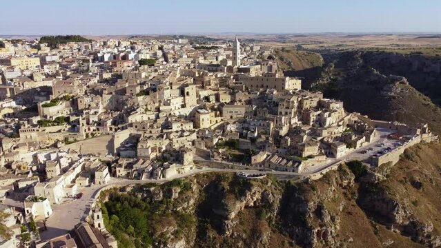 Aerial footage of Sassi di Matera in Basilicata, South Italy.Drone 360 orbit from Sasso Caveoso, Civita, Barisano district, old city houses carved in rock caves, bell tower of Cathedral, from above.