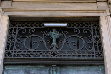 Ancient Roman cross on the entrance doors to the church. Secret symbols and signs