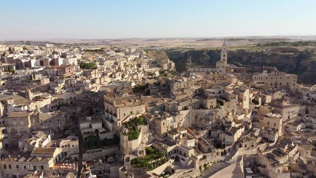 Aerial footage of Sassi di Matera, Basilicata, South Italy.Drone view of old city houses carved in rock caves, stairs, the bell tower of Cathedral of Matera, a Unesco world heritage site from above