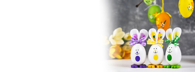 Vase with branches decorated with Easter eggs. Funny bunnies made of eggshells.Easter decoration, space for a text.