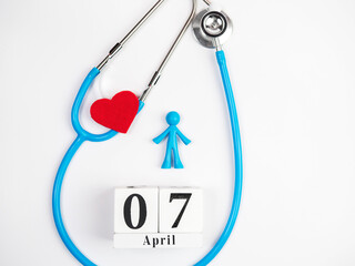 Stetascope with hearts on a light-coloured background with calendar and human figures. Concept of medicine, healing, health. World Health Day.