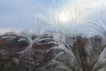 Patterns from frost on the surface of the window glass. Background with selective focus