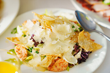 a white plate of Caesar salad. chicken salad with cheese and vegetables. 