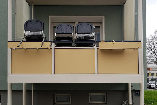 Drei Stühle auf Balkonbrüstung