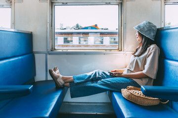 Traveler asian woman with mobile phone travel by train in Thailand