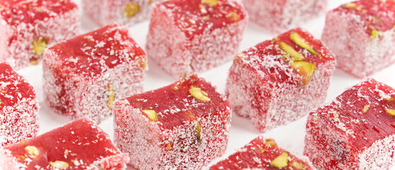 
Contains Turkish delight or greek delight ,  pomegranate, pistachio and coconut lined up on a white background