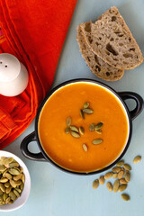 Healthy pumpkin soup with vegetables and pumpkin seeds - 575915821